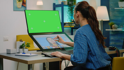 Woman with horizontal green screen editing photos on touch screen monitor. Photographer working...