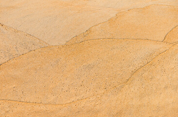Wave pattern on sand beach, blank brown sand texture background