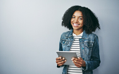You HAVE to go wireless. Studio portrait of an attractive young woman using her digital tablet...