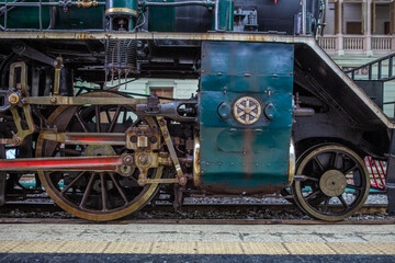 Fototapeta na wymiar Closeup Wheels and drive device of old steam locomotive