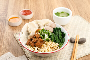 Mie ayam (noodles with chicken, meatballs, dumplings and vegetables) is a popular street food in...