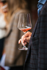 hand with a glass of rosé wine at a wine tasting