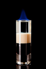 short layered alcoholic cocktail on black background