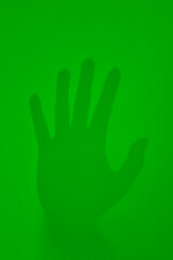 Naklejka na ściany i meble On a green background is the imprint of a man's hand.