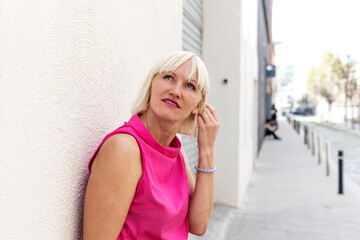 Fototapeta premium Pretty young city girl standing against an exterior wall