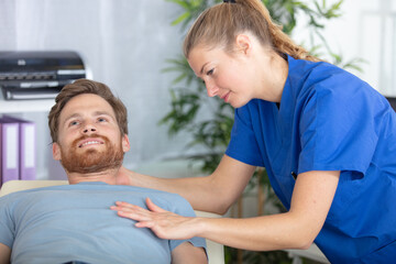 female physiotherapist doing manipulative spine treatment on young patient