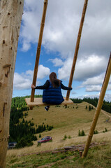 girl on a big swing in the mountains
