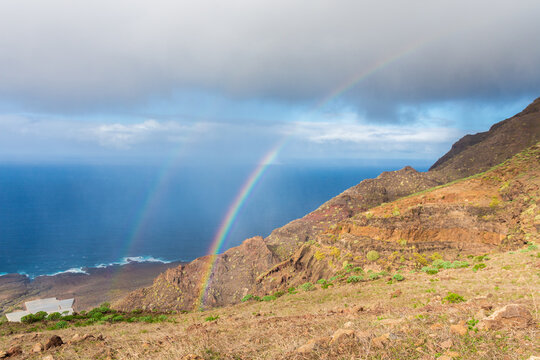 Atlantic Ocean on the island of Tenerife. Gigint rocks on the Canary Islands.Rainbow over the mountains.