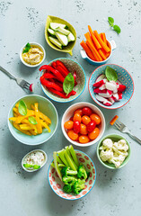 Fresh, raw, sliced vegetables in a colorful bowls. Healthy party snacks - vegetarian or vegan diet.