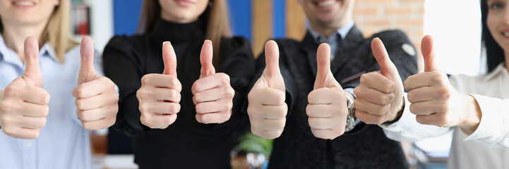 Group of students showing thumbs up in office closeup