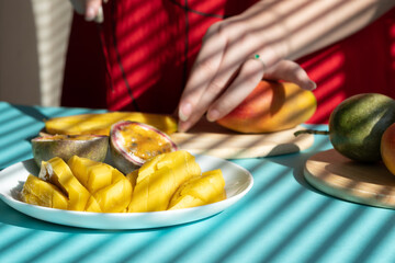 chef cutting fruits. Female hands cutting mango and passion fruit, fruit breakfast
