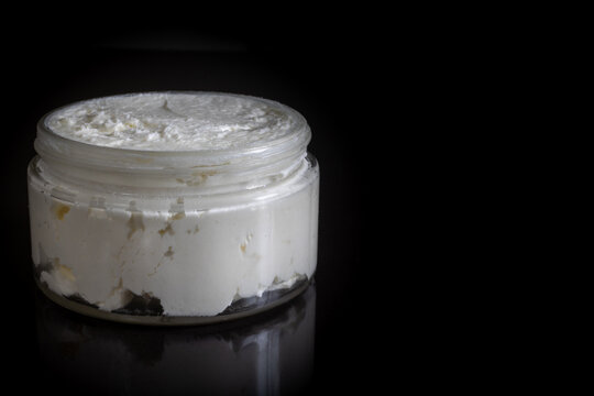 open jar of fresh whipped body butter isolated on black