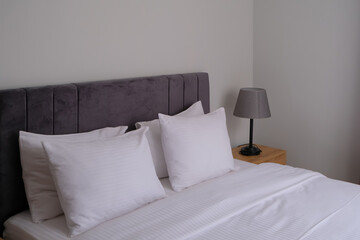 Fototapeta na wymiar clean modern bedroom with white bedding. minimal interior. good sleep and relaxation