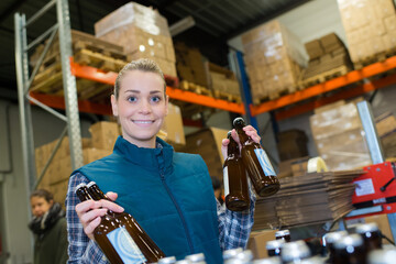 portrait of female worker holding bottles of beer