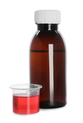 Bottle of cough syrup and measuring cup on white background