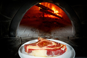 the chef puts the wet-aged steak in the stone oven 
