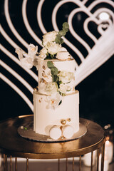 a white wedding cake is decorated with flowers and stands in the buffet area, which is decorated with designer designs and flower arrangements