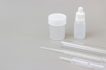 test tubes, pipettes and flasks lie on a gray background