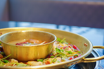 spicy sichuan hot pot with sliced fish meat, red chili pepper and coriander