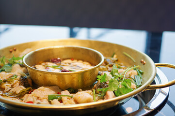 copper yuanyang hot pot with fish, red chili pepper and coriander