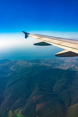 Fototapeta premium View from the airplane window at a beautiful blue clear sky and the airplane wing