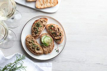 Slices of bread with delicious pate served on white wooden table, flat lay. Space for text