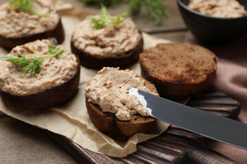 Slices of bread with delicious pate on wooden table, closeup