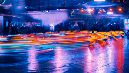 Illuminated lights of bumper cars at a funfair at night with abstract motion blur due to long time...