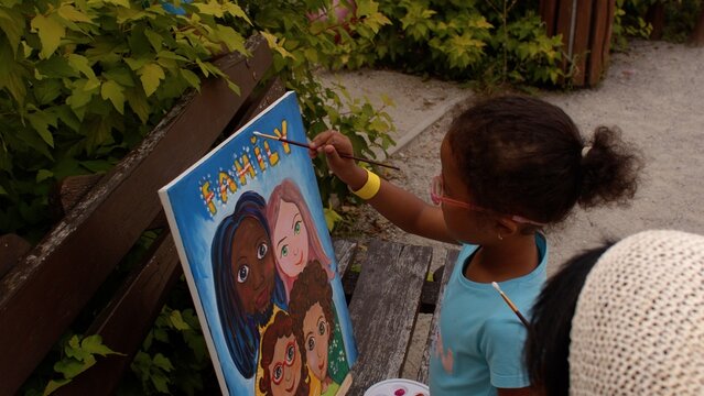 Talented child is painting on canvas. Artistically gifted student exhibit a strong sense of creativity, use interesting materials, and test artistic boundaries. 