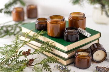 A set of different aroma candles in brown glass jars. Scented handmade candle. Soy candles are burning in a jar. Aromatherapy and relax in spa and home. Still life. Fire in brown jar