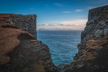 Faroe Islands Traelanipa the slaves rock cliff is seen rising over the ocean next to lake Sorvagsvatn. Clouds and blue sky during autumn on the island vagar in the Faroe Islands. November 2021