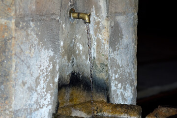 A water fountain built of stone. Selective focus