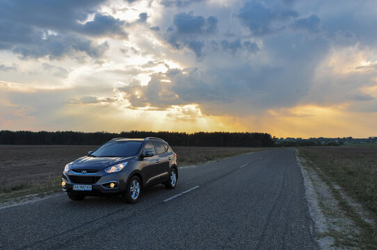 KYIV, UKRAINE-JULY 1, 2021: SUV Hyundai ix35 on asphalt road on a summer day in the countryside. Vehicle for traveling. Automotive photography. Space for text. Rental car. Landscape with road and car.