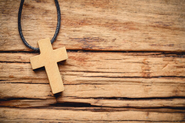 Wooden Christian cross on table, top view. Space for text