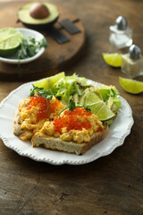 Scrambled eggs with red caviar on toast