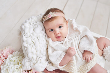 Fototapeta na wymiar Cute baby girl in knitted clothes and wreath. Mother's day greeting card. International day of happiness