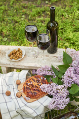 Summer picnic in garden. Wine, pie, fruits and flowers. Still life. Easter lunch and table