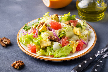 Salad with grapefruit, cheese and walnut on a plate