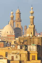 Cairo, Egypt - January 2022: Aerial view over a dome and minarets of mosques in the city centre at sunset