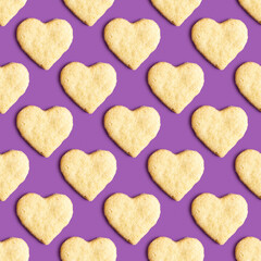 Seamless pattern with butter cookies in the form of heart on purple background.