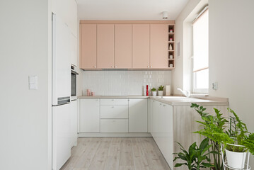 Kuchnia w minimalistycznym nowoczesnym stylu. Białe i różowe fronty mebli oraz sprzęt. Biała lodówka - obrazy, fototapety, plakaty
