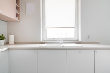 Detal w kuchni w minimalistycznym nowoczesnym stylu. Białe i różowe fronty mebli oraz sprzęt.
