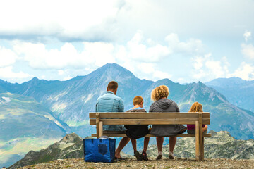 Family resting on bench in Alps, France with beautiful mountain view. Family vacation background. Picnic. Freedom, travel, relationship concepts