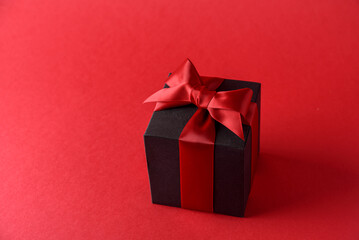 Red gift box with red bow on red background
