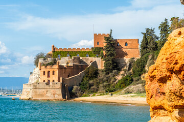 Coastline with sandy beach and castle in Ferragudo, Algarve, Portugal