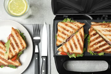 Zelfklevend Fotobehang Flat lay composition with modern sandwich maker and breakfast served on grey table © New Africa