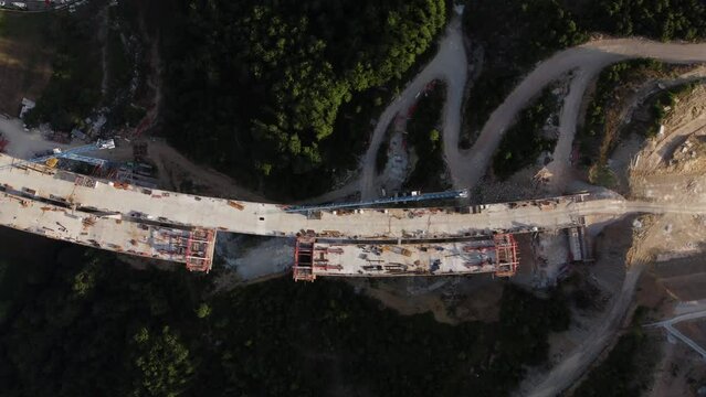 Highway bridge under construction. Aerial view of nes road. Freeway being built on a mountain terrain..