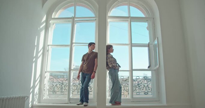 at two large windows, in one apartment, a man and a woman are separated. quarrel or misunderstanding, the desire to apologize and establish a relationship, a breakup, a divorce. 