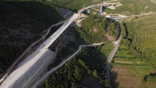 Highway bridge under construction. Aerial view of nes road. Freeway being built on a mountain terrain..