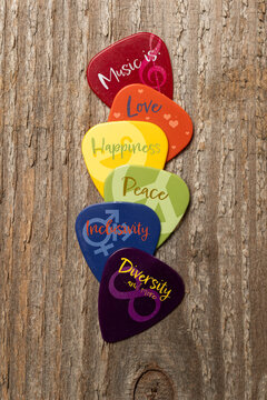 Power of music concept: five guitar picks with graphic and text for love happiness peace inclusivity and diversity